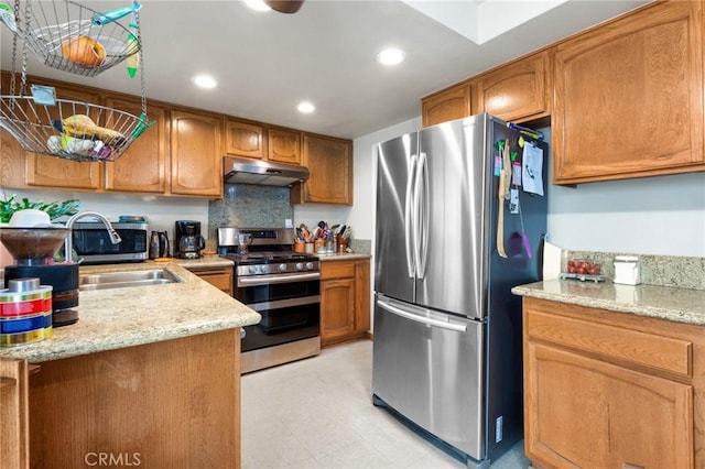 410 N Broadway Unit C, Redondo Beach, CA 90277 - kitchen with stainless steel appliances, under cabinet range hood, brown cabinetry, recessed lighting, and light stone countertops