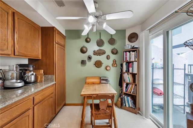 410 N Broadway Unit C, Redondo Beach, CA 90277 - kitchen with brown cabinetry, a ceiling fan, and light stone countertops