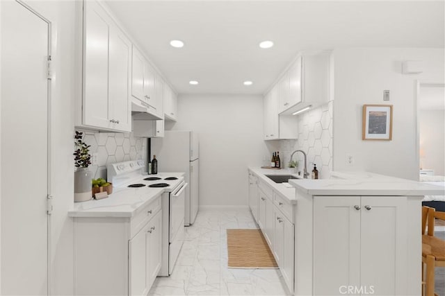 4210 Via Arbolada Unit 105, Los Angeles, CA 90042 - kitchen featuring white appliances, a peninsula, light marble finish flooring, a breakfast bar area, and tasteful backsplash