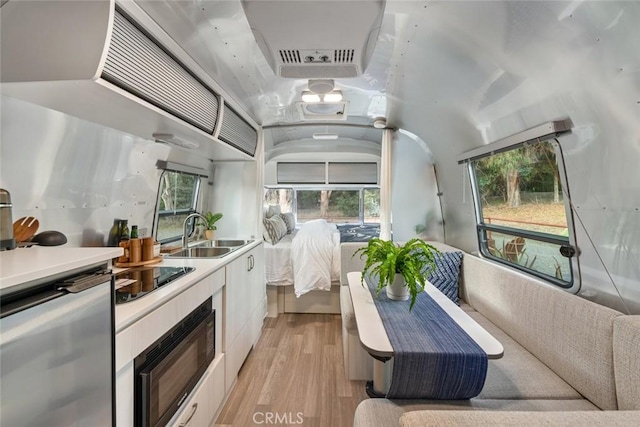 1186 Ramblin Rose Way, Arroyo Grande, CA 93420 - kitchen with black appliances, light wood-type flooring, white cabinetry, and plenty of natural light