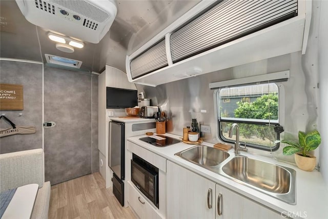 1186 Ramblin Rose Way, Arroyo Grande, CA 93420 - kitchen featuring black microwave, light wood-style flooring, light countertops, white cabinets, and cooktop