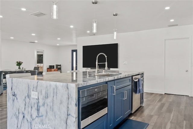 1954 Shipway Ave, Long Beach, CA 90815 - kitchen featuring stainless steel dishwasher, a large island with sink, light stone countertops, light wood-style flooring, and decorative light fixtures