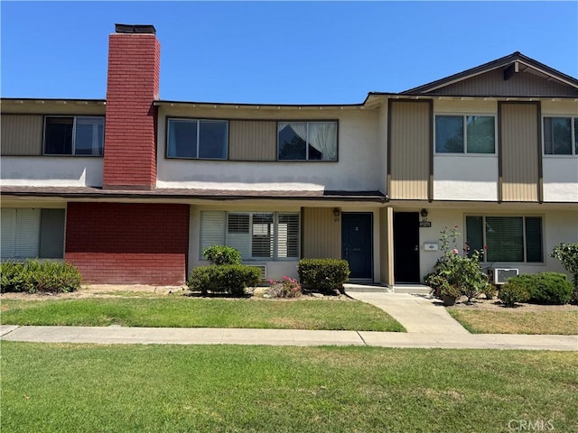 1722 Mitchell Ave Unit 123, Tustin, CA 92780 - view of property featuring a chimney, brick siding, and a front yard
