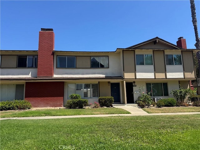1722 Mitchell Ave Unit 123, Tustin, CA 92780 - view of property featuring a chimney, a front yard, and brick siding