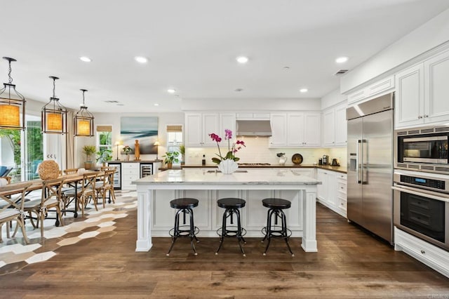 196 Coral Cove Way, Encinitas, CA 92024 - kitchen with built in appliances, ventilation hood, white cabinetry, backsplash, and dark wood-style flooring