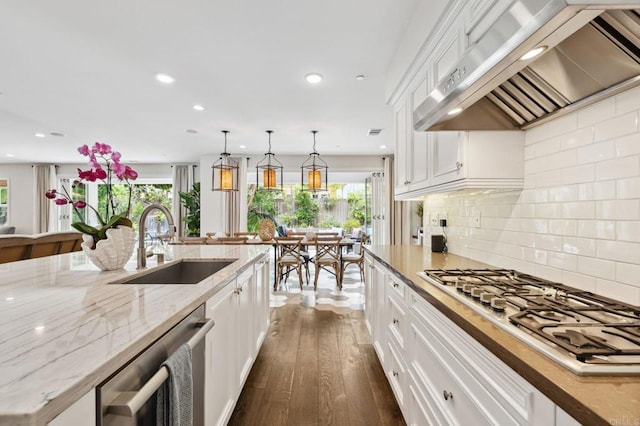 196 Coral Cove Way, Encinitas, CA 92024 - kitchen with wall chimney range hood, stainless steel appliances, white cabinets, dark wood finished floors, and recessed lighting