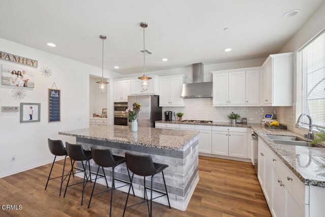 113 Azalea St, Fillmore, CA 93015 - kitchen featuring wall chimney exhaust hood, appliances with stainless steel finishes, a center island, white cabinetry, and recessed lighting
