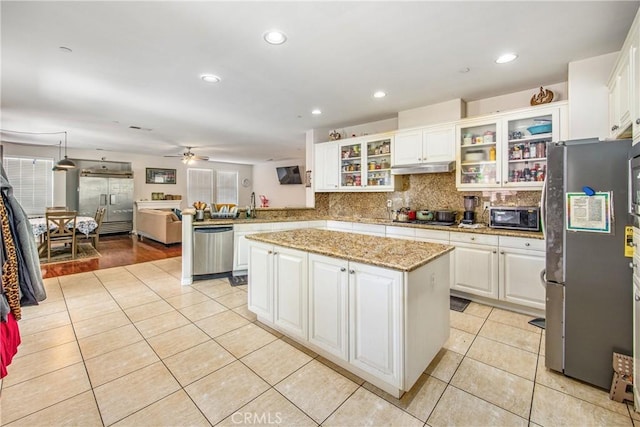 190 Cross Rail Ln, Norco, CA 92860 - kitchen featuring stainless steel appliances, a peninsula, light tile patterned flooring, tasteful backsplash, and white cabinetry