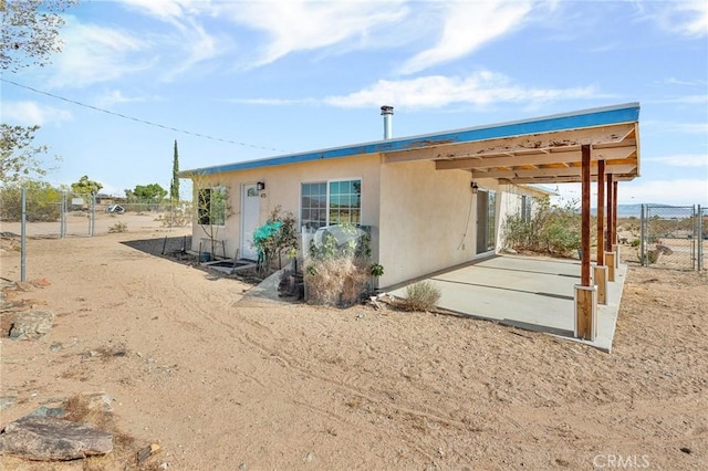 475 Fair Acres, Landers, CA 92285 - rear view of property with a patio, stucco siding, and a gate