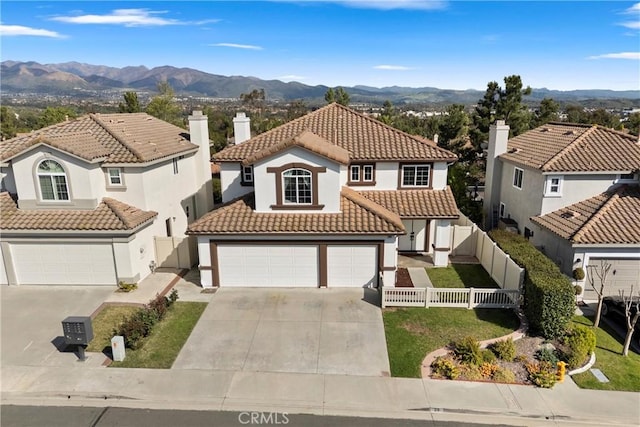 36 Via Tronido, Rancho Santa Margarita, CA 92688 - mediterranean / spanish-style home featuring stucco siding, driveway, a tile roof, a mountain view, and a chimney