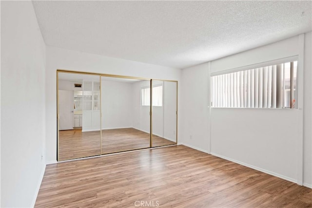 5500 Lindley Ave Unit 206, Encino, CA 91316 - unfurnished bedroom featuring wood finished floors, a closet, and a textured ceiling