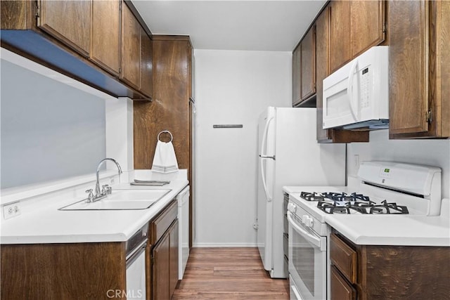 5500 Lindley Ave Unit 206, Encino, CA 91316 - kitchen featuring white appliances, wood finished floors, light countertops, and dark brown cabinets