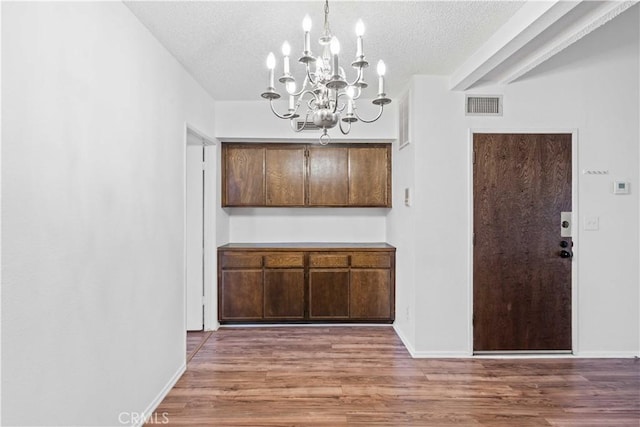 5500 Lindley Ave Unit 206, Encino, CA 91316 - unfurnished dining area with a chandelier, a textured ceiling, and wood finished floors