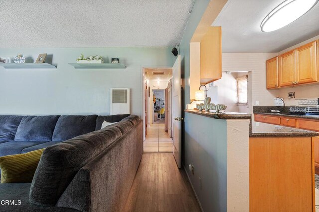 272 E 69th St, Long Beach, CA 90805 - kitchen with open floor plan, light brown cabinets, light wood-type flooring, a peninsula, and dark stone counters
