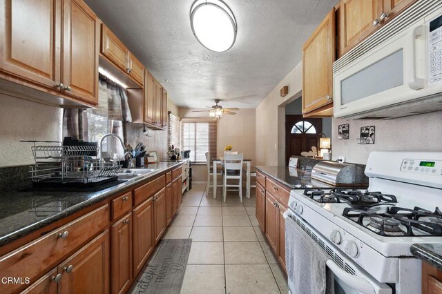 272 E 69th St, Long Beach, CA 90805 - kitchen with white appliances, ceiling fan, a textured ceiling, light tile patterned floors, and brown cabinetry