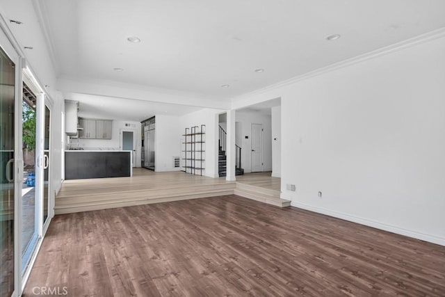 7812 Fairchild Ave, Winnetka, CA 91306 - unfurnished living room featuring stairs, wood finished floors, crown molding, and recessed lighting