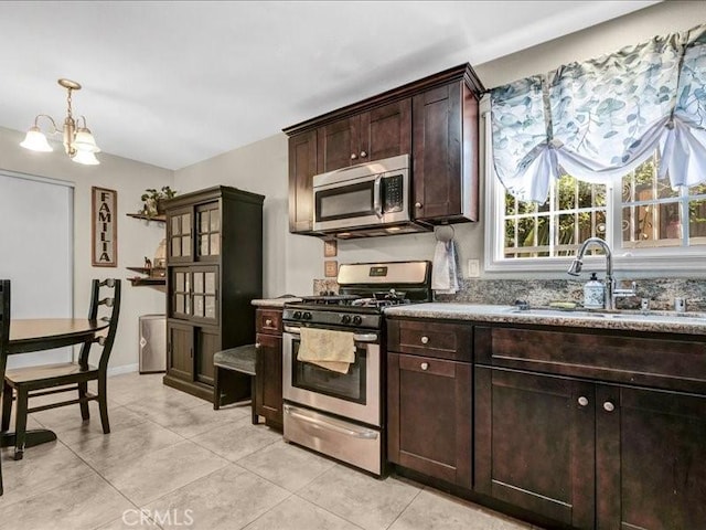 10316 S San Pedro St, Los Angeles, CA 90003 - kitchen with appliances with stainless steel finishes, dark brown cabinetry, light tile patterned flooring, and a chandelier