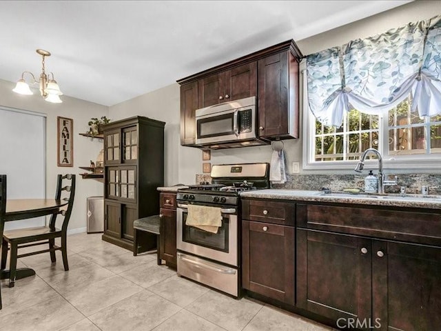 10316 S San Pedro St, Los Angeles, CA 90003 - kitchen with appliances with stainless steel finishes, dark brown cabinetry, light tile patterned floors, and a chandelier