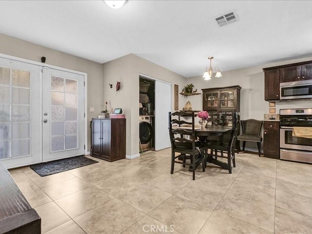 10316 S San Pedro St, Los Angeles, CA 90003 - dining room with washer / dryer, a chandelier, light tile patterned floors, and french doors