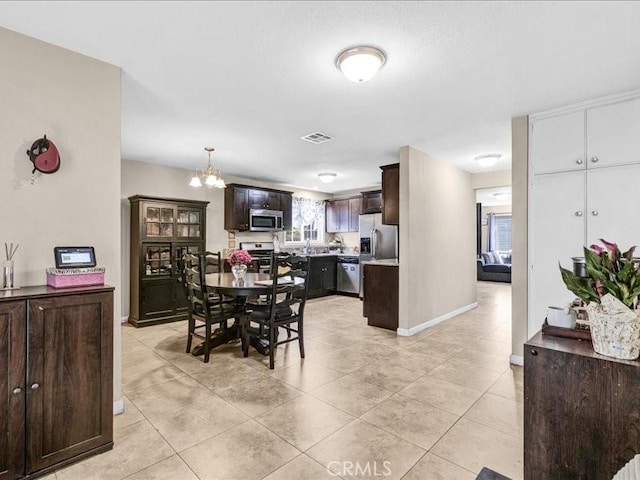 10316 S San Pedro St, Los Angeles, CA 90003 - dining room with light tile patterned floors and a chandelier