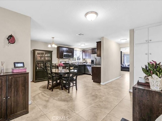 10316 S San Pedro St, Los Angeles, CA 90003 - dining space with light tile patterned flooring and a chandelier