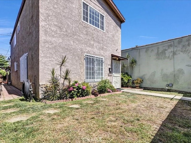 10316 S San Pedro St, Los Angeles, CA 90003 - back of property with stucco siding and a lawn