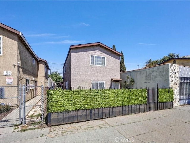10316 S San Pedro St, Los Angeles, CA 90003 - view of home's exterior with a gate and stucco siding