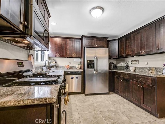 10316 S San Pedro St, Los Angeles, CA 90003 - kitchen with appliances with stainless steel finishes, dark brown cabinetry, light tile patterned floors, and light stone countertops