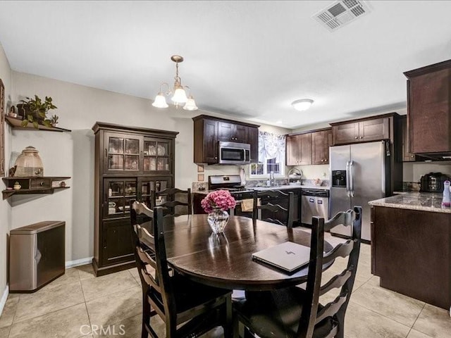 10316 S San Pedro St, Los Angeles, CA 90003 - dining area featuring light tile patterned floors and a chandelier