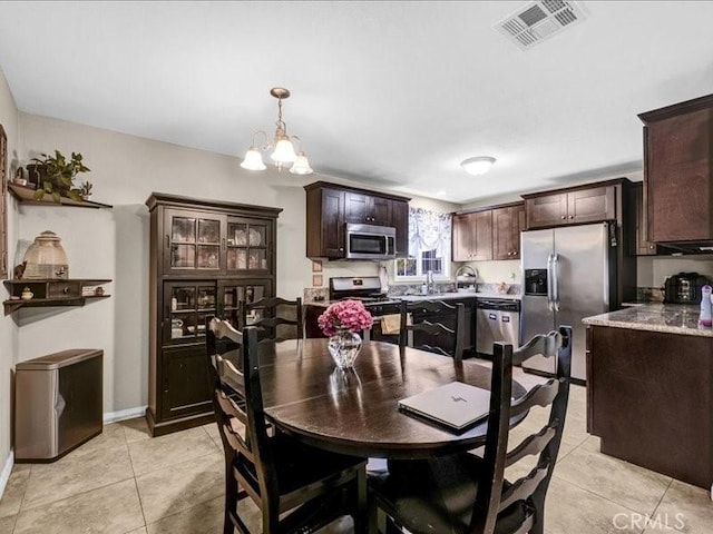 10316 S San Pedro St, Los Angeles, CA 90003 - dining room featuring light tile patterned floors and a chandelier