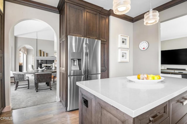 1758 Emerald Isle Way, Oxnard, CA 93035 - kitchen with stainless steel fridge with ice dispenser, ornamental molding, arched walkways, light wood finished floors, and dark brown cabinets