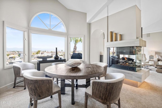1758 Emerald Isle Way, Oxnard, CA 93035 - dining room featuring carpet flooring, high vaulted ceiling, a multi sided fireplace, and arched walkways
