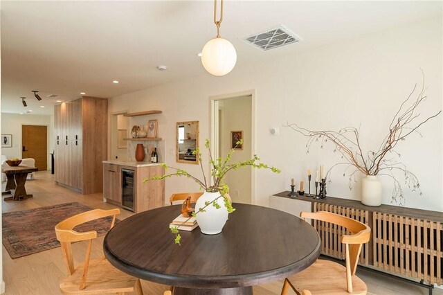 2404 Glover Pl, Los Angeles, CA 90031 - dining room with radiator heating unit, beverage cooler, light wood finished floors, and recessed lighting