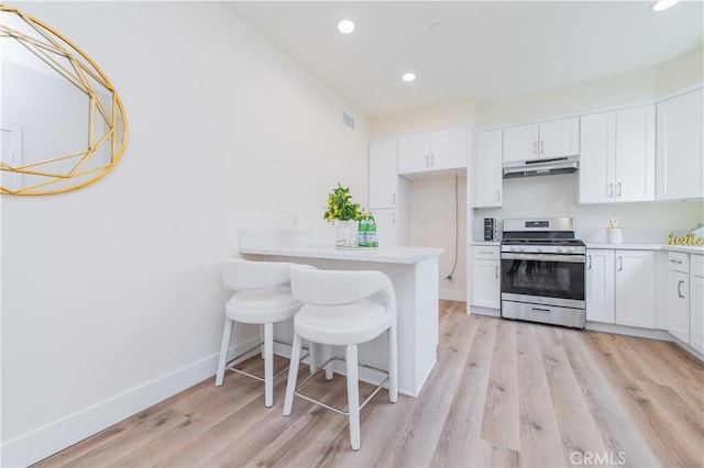 11237 Gladhill Rd Unit 12, Whittier, CA 90604 - kitchen featuring stainless steel gas stove, under cabinet range hood, white cabinetry, recessed lighting, and light wood-style flooring