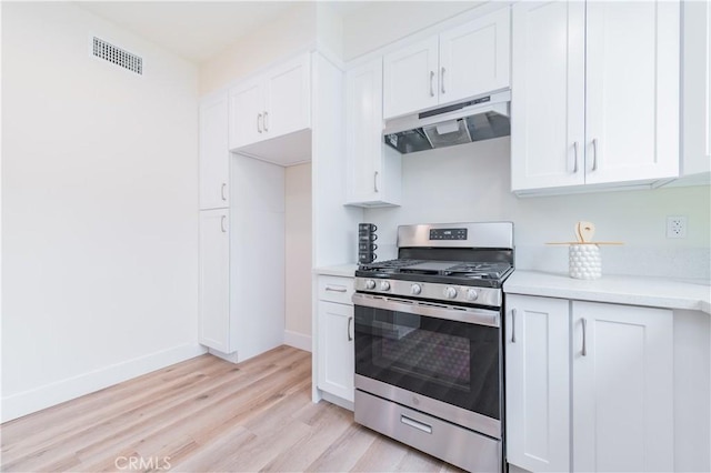 11237 Gladhill Rd Unit 12, Whittier, CA 90604 - kitchen featuring gas range, under cabinet range hood, light wood-type flooring, light countertops, and white cabinetry