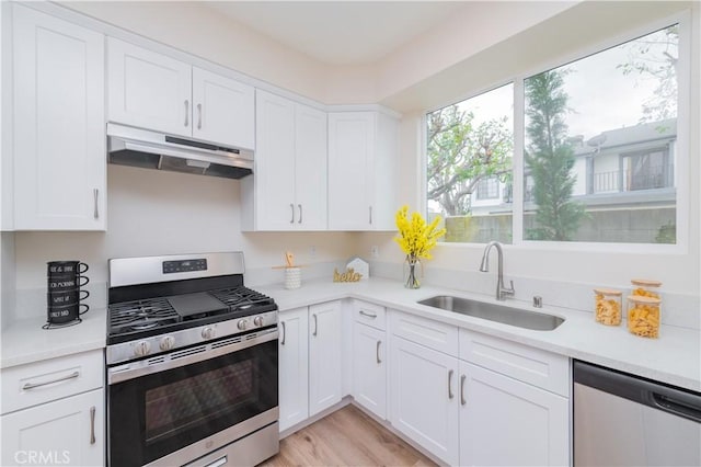 11237 Gladhill Rd Unit 12, Whittier, CA 90604 - kitchen with stainless steel appliances, under cabinet range hood, light countertops, and white cabinets