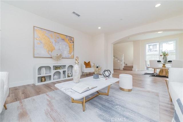 11237 Gladhill Rd Unit 12, Whittier, CA 90604 - living area with arched walkways, wood finished floors, stairway, and recessed lighting