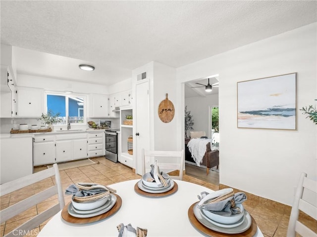 1263 Bundy Ave, Clovis, CA 93611 - kitchen featuring stainless steel range with electric stovetop, white cabinetry, light countertops, a textured ceiling, and light tile patterned floors