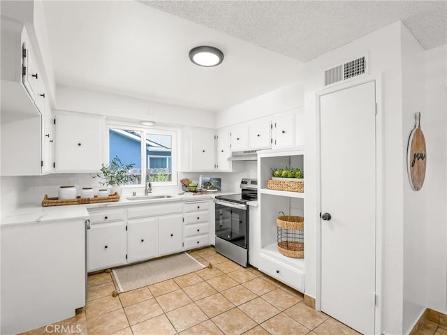 1263 Bundy Ave, Clovis, CA 93611 - kitchen with electric stove, under cabinet range hood, white cabinetry, light countertops, and light tile patterned flooring