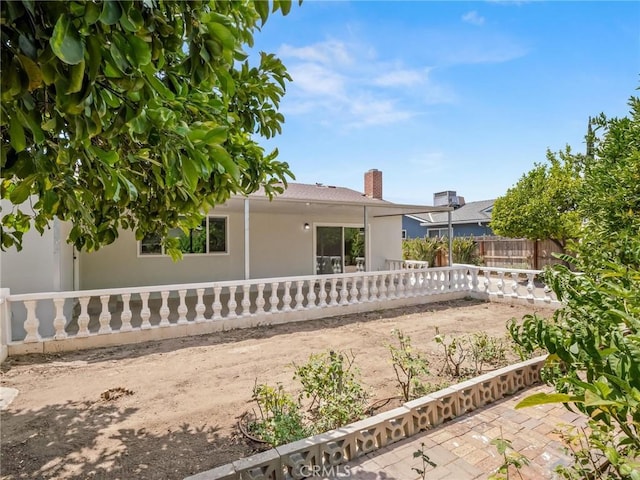 1263 Bundy Ave, Clovis, CA 93611 - rear view of house featuring a patio, stucco siding, and a chimney