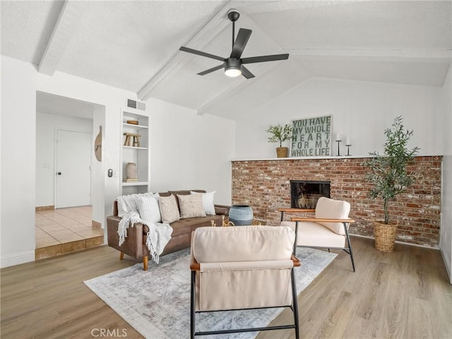 1263 Bundy Ave, Clovis, CA 93611 - living area featuring wood finished floors, a brick fireplace, ceiling fan, and built in shelves