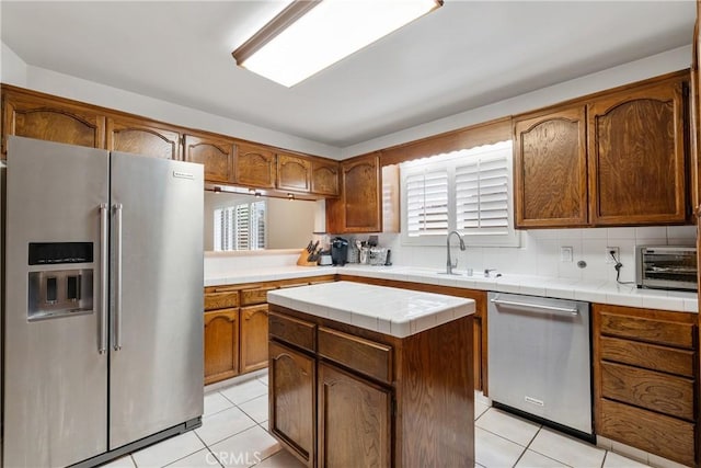 6636 Wooster Ave, Los Angeles, CA 90056 - kitchen featuring stainless steel appliances, light tile patterned floors, tile countertops, and tasteful backsplash