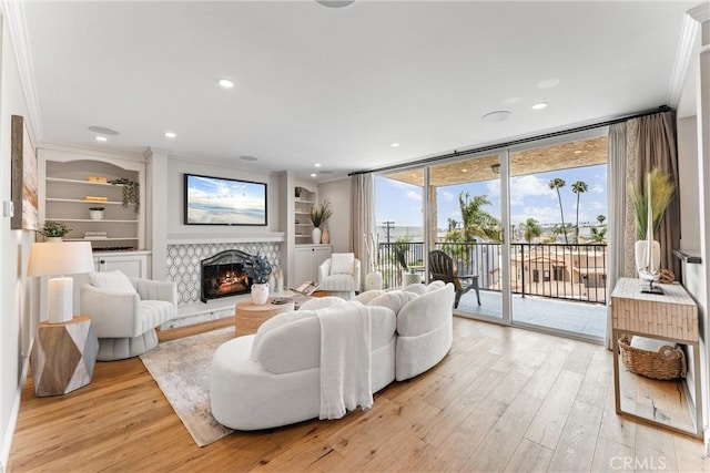 201 Bay Shore Ave Unit 305, Long Beach, CA 90803 - living room with light wood-type flooring, a warm lit fireplace, ornamental molding, recessed lighting, and floor to ceiling windows