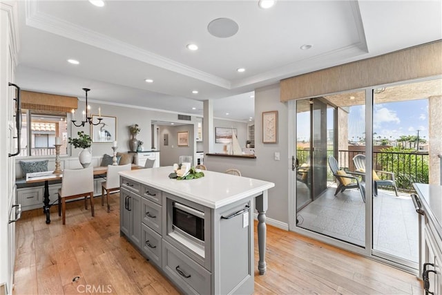 201 Bay Shore Ave Unit 305, Long Beach, CA 90803 - kitchen featuring a tray ceiling, gray cabinets, ornamental molding, stainless steel microwave, and light wood-style floors