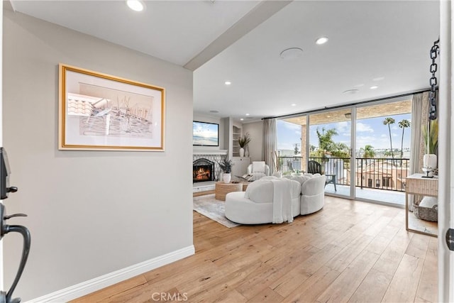 201 Bay Shore Ave Unit 305, Long Beach, CA 90803 - living area featuring light wood finished floors, a warm lit fireplace, expansive windows, and recessed lighting