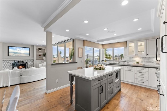 201 Bay Shore Ave Unit 305, Long Beach, CA 90803 - kitchen with gray cabinets, a tray ceiling, recessed lighting, a breakfast bar area, and light wood finished floors