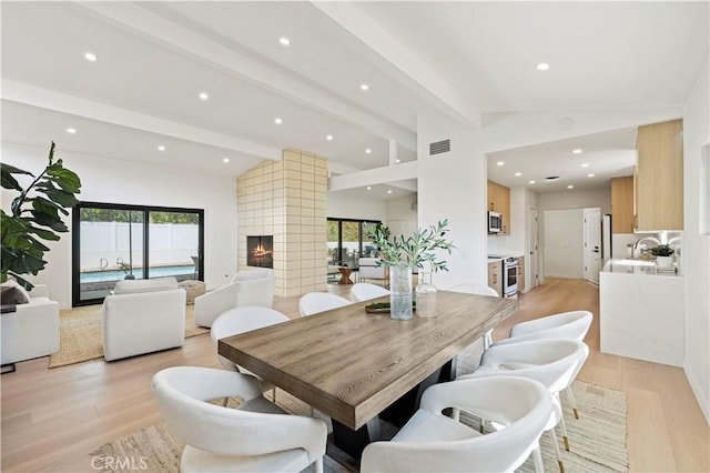 2414 Las Positas Rd, Glendale, CA 91208 - dining space with healthy amount of natural light, light wood finished floors, recessed lighting, and a multi sided fireplace