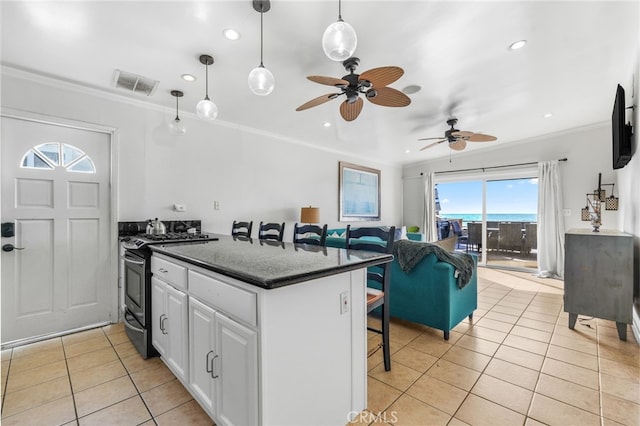 35171 Beach Rd, Dana Point, CA 92624 - kitchen featuring gas range, crown molding, light tile patterned flooring, white cabinetry, and a kitchen bar
