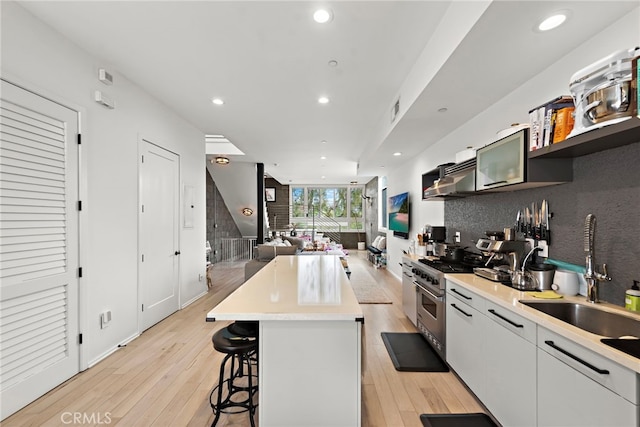 4151 Redwood Ave Unit 106, Los Angeles, CA 90066 - kitchen featuring high end range, a kitchen bar, light wood-style floors, light countertops, and recessed lighting