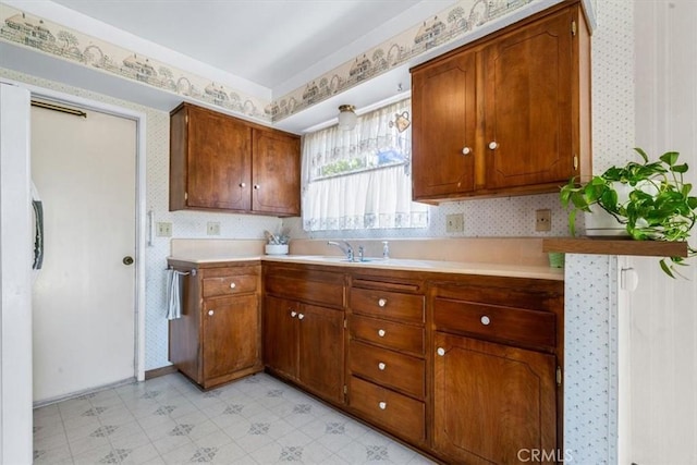 1283 W Newport St, San Luis Obispo, CA 93405 - kitchen with wallpapered walls, light countertops, light flooring, and brown cabinets